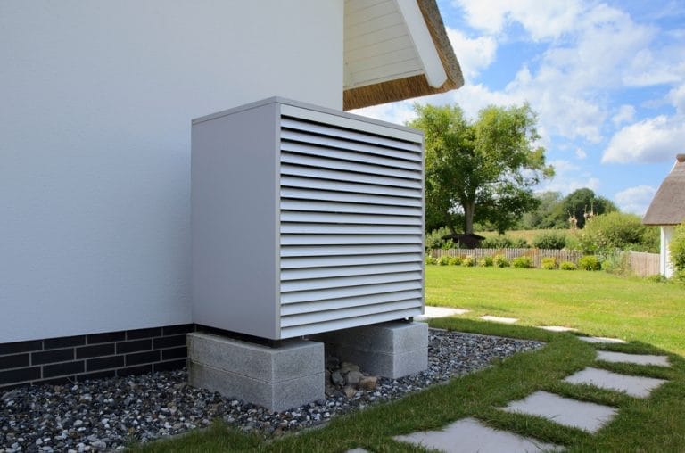 Luft-Wasser-Wärmepumpe Außeneinheit vor einem Einfamilienhaus
